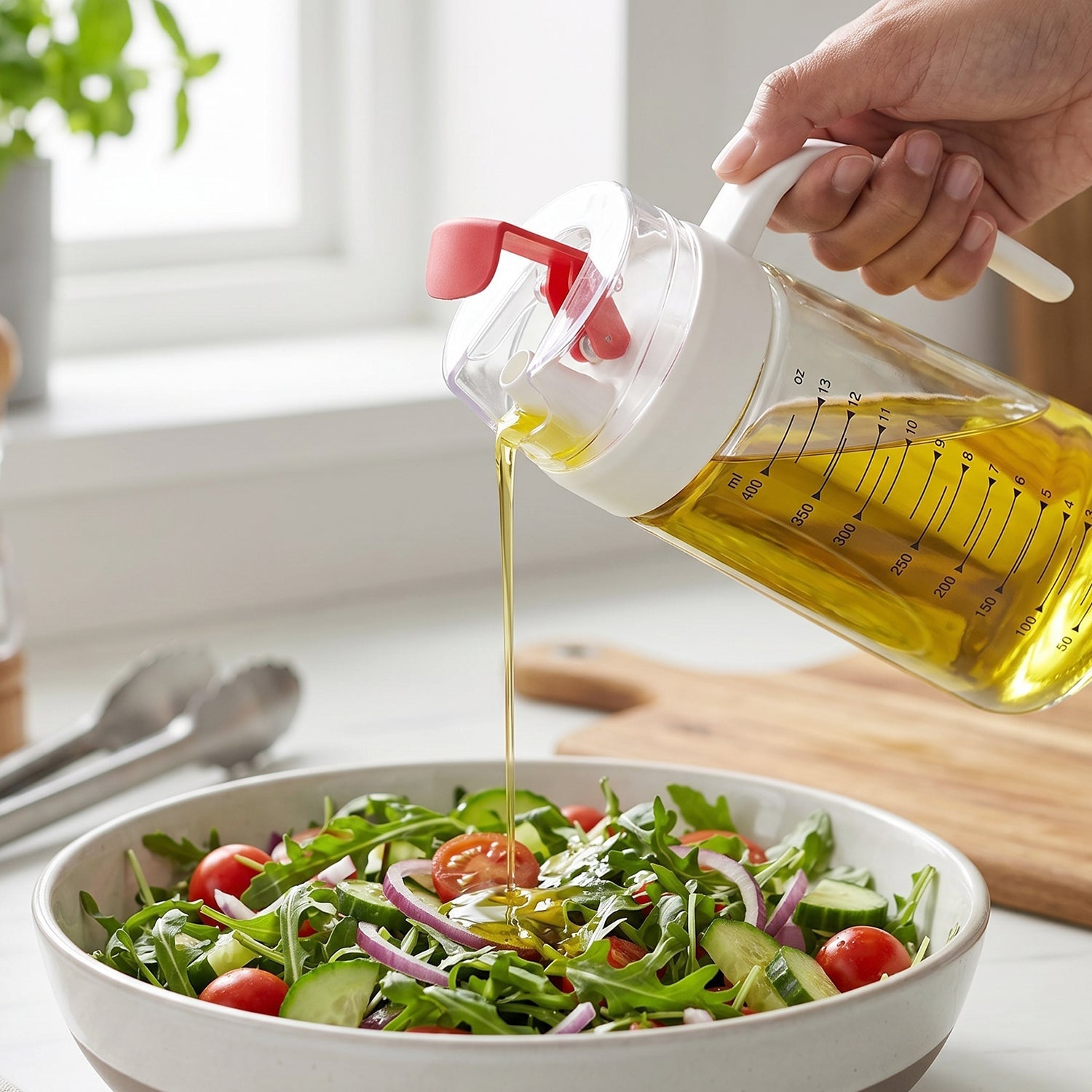 Hand Holding 500ml Glass Oil Bottle with Red Flip Cap Drizzling Olive Oil onto Arugula Salad with Cherry Tomatoes and Red Onion